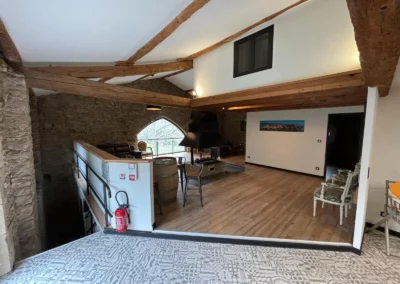 Grande pièce à vivre avec cheminée centrale au Gîte du Clot de Castres, disponible à la location pour week-end ou vacances.